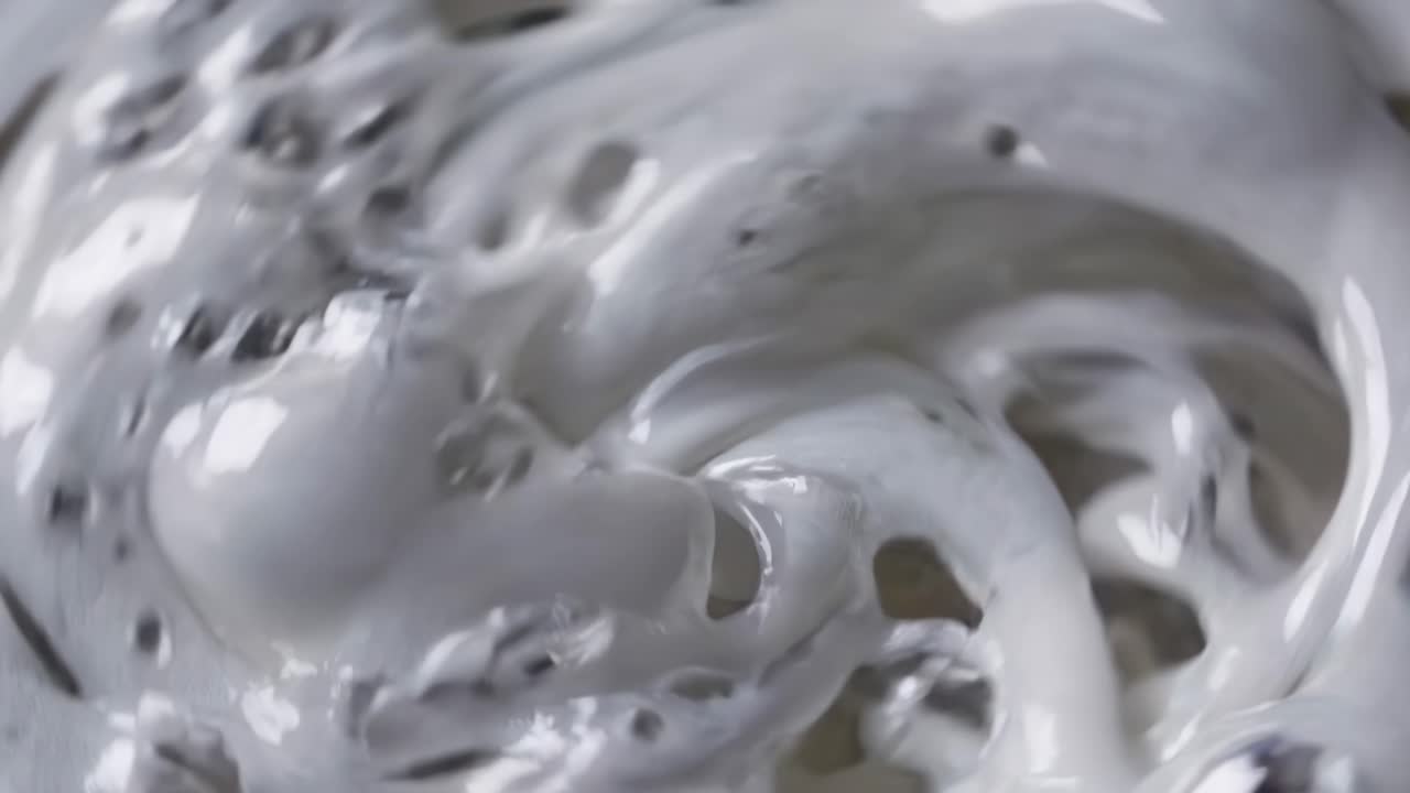Close-up video of swirling white liquid with a smooth, creamy texture