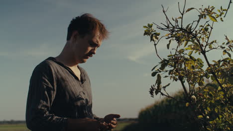 a man interacting with a plant outdoors