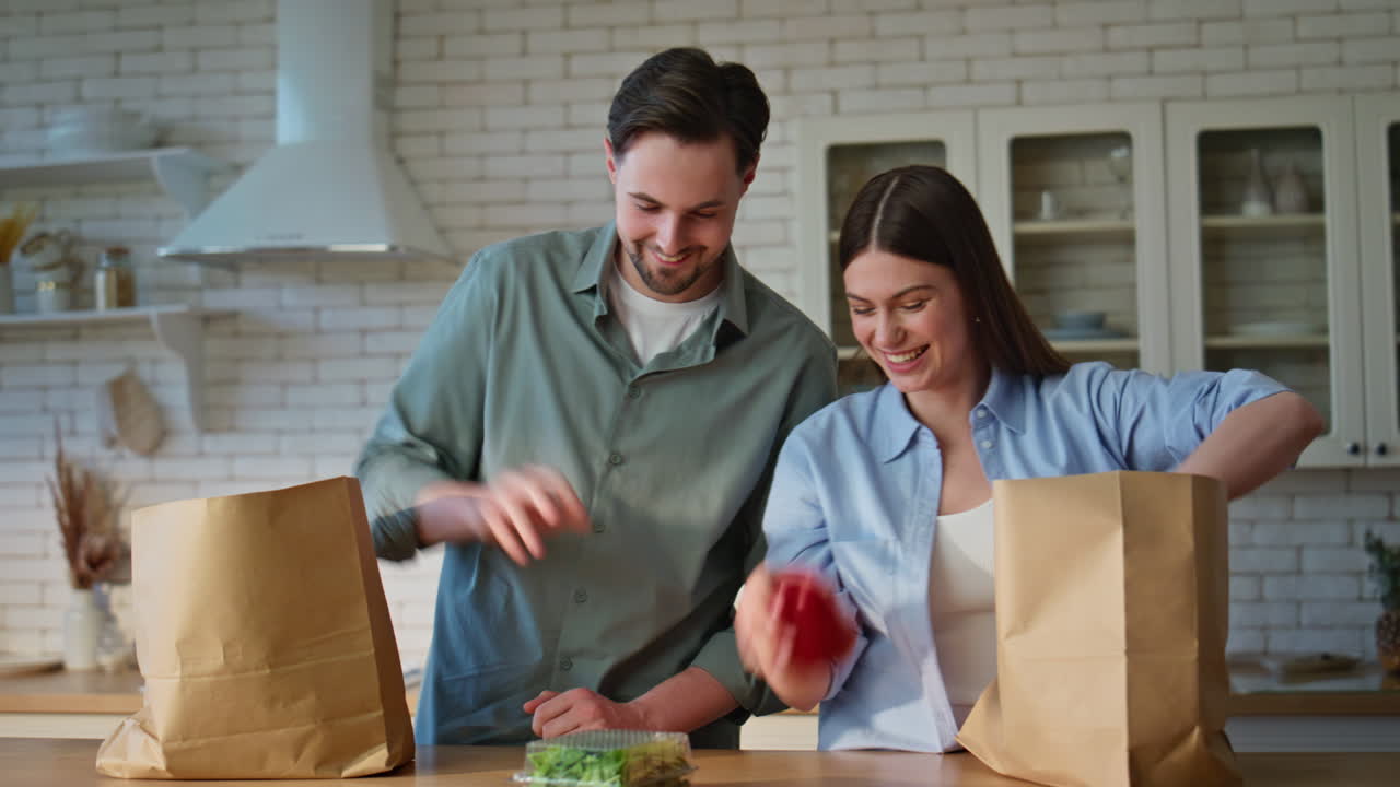Couple arrived grocery store putting shoppings on kitchen countertop closeup