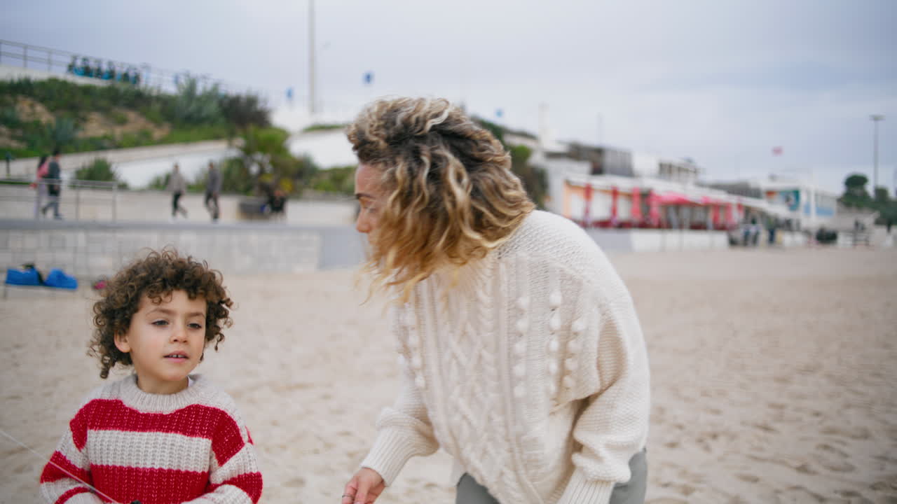 Madre e figlio che camminano sulla spiaggia in primavera. Famiglia amorevole che si gode il fine settimana all'aperto.