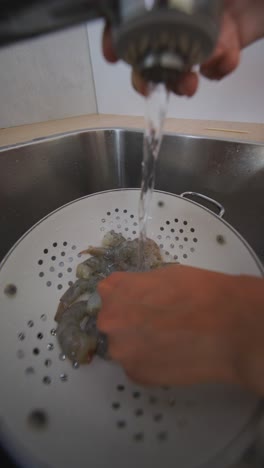 washing raw shrimp in a kitchen sink
