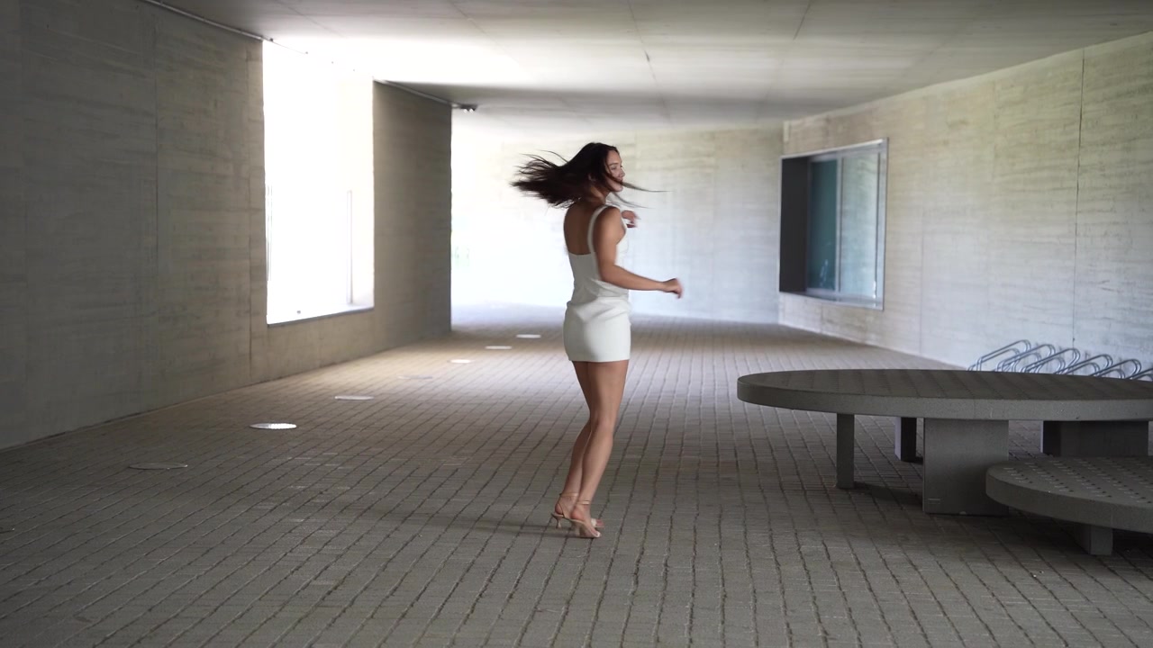 Una donna elegante posa con grazia in un ambiente architettonico moderno ed elegante