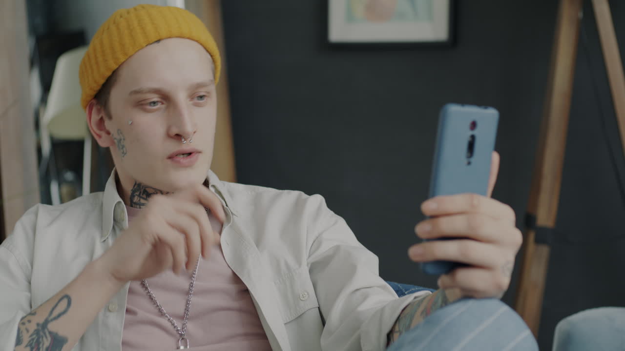 Young man using smartphone in conversation