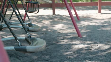 Close up of empty swing set swaying in suburb Botkyrka, Stockholm