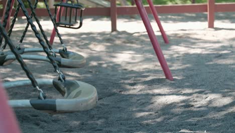 close up of empty swing set swaying in suburb botkyrka, stockholm