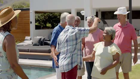 happy diverse senior friends talking and embracing at sunny garden party, unaltered, in slow motion