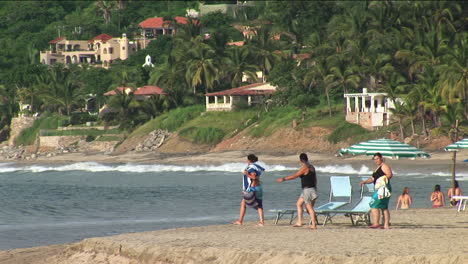 Three-people-walk-to-the-water-at-a-beach-resort