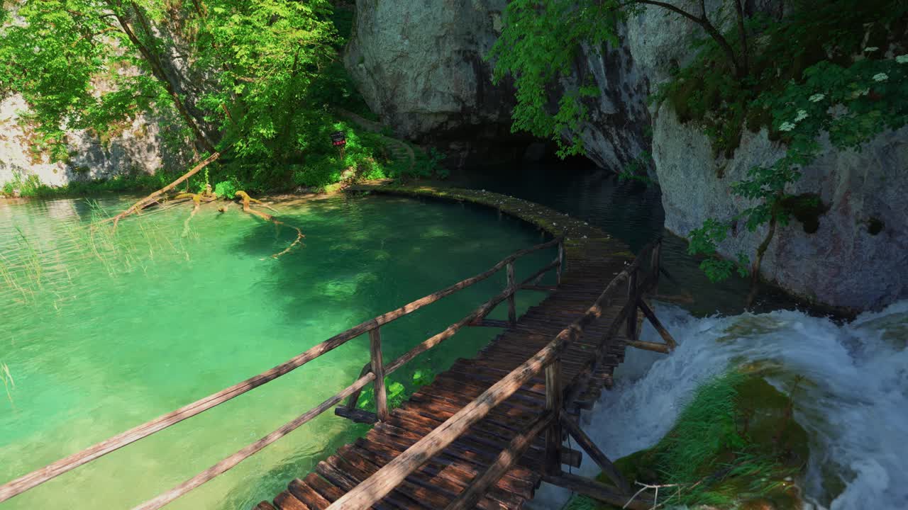Plitvice Croatia waterfall flowing through rocks surrounded by lush spring nature and wooden paths