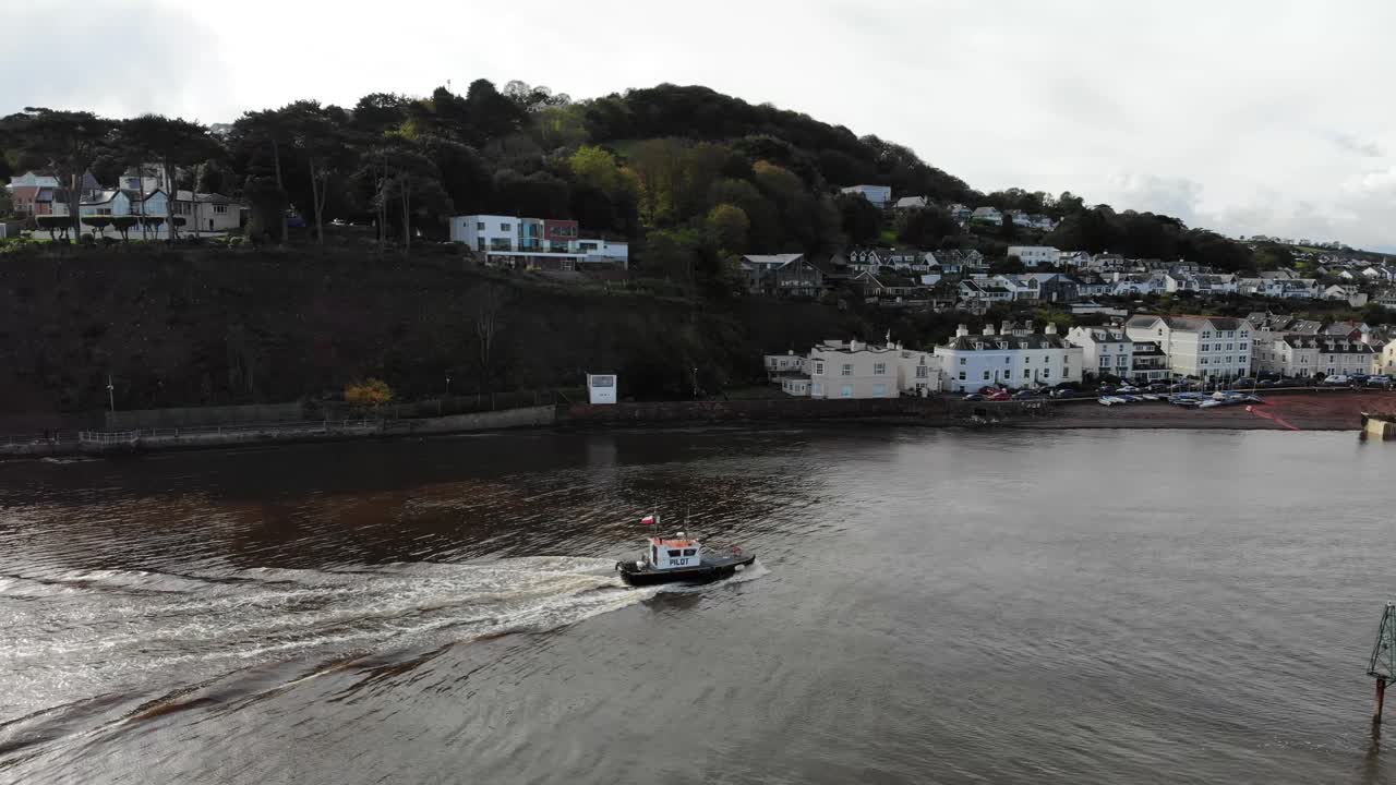 pequeño barco arrastrero que llega al río teign con shaldon beach en segundo plano.