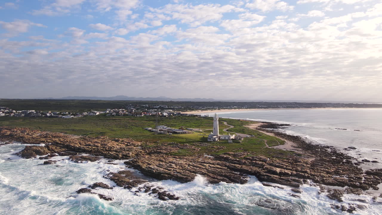 Arcing sunrise aerial view of Seal Point lighthouse in Cape St Francis