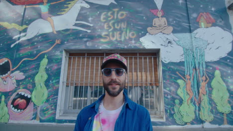 portrait of street artist against graffiti wall outdoors in the city