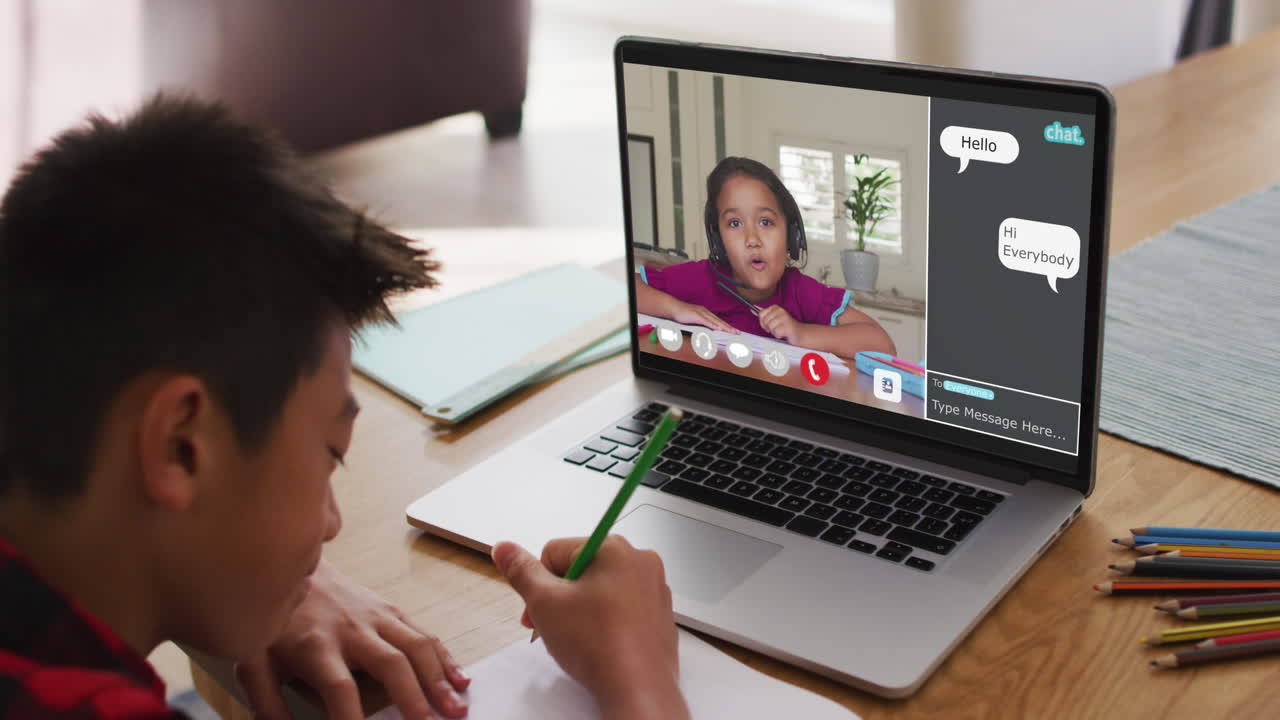 escolar que usa una computadora portátil para una lección en línea en casa, con una estudiante y un webchat en la pantalla