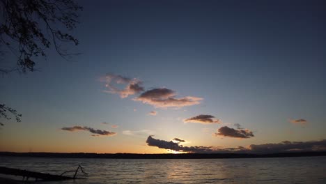 beautiful hyper time lapse golden hour to blue to black clouds boiling sunset looking out over puget sound, pan right