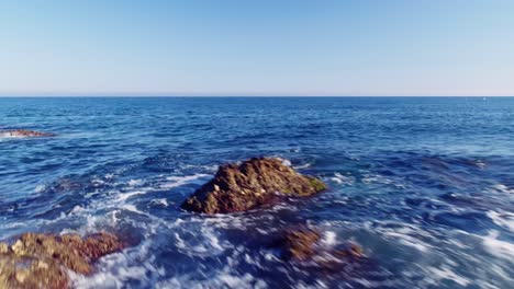 drone che vola veloce vicino alla costa rocciosa e si sposta più in alto per rivelare il mare