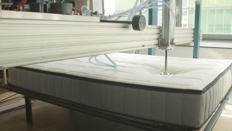 Mattress-being-tested-with-hydraulic-press-in-mattress-production-facility---medium