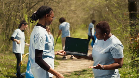 Las-Mujeres-Afroamericanas-Usan-Una-Computadora-Portátil-Con-Pantalla-Verde-Durante-La-Limpieza-De-Basura