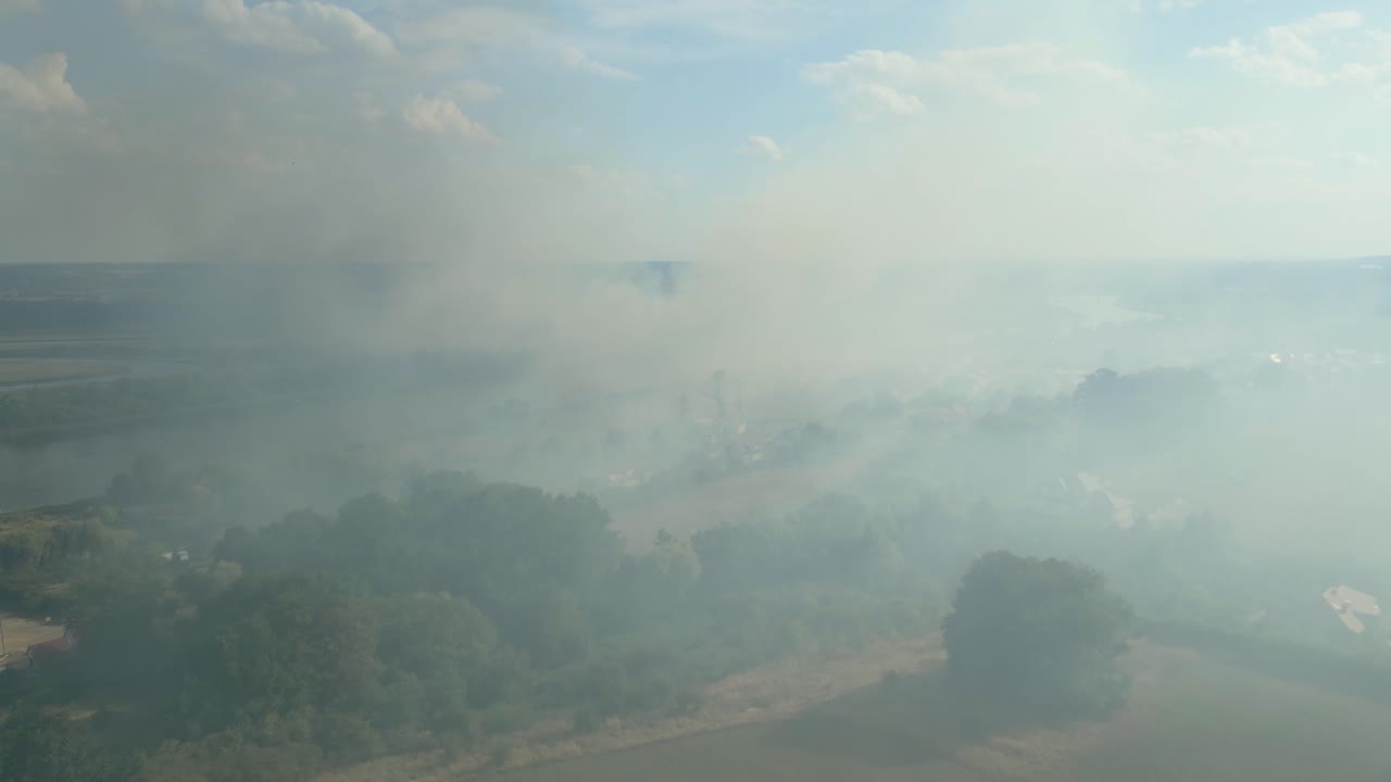 Wildfire smoke over Szczecin fields near the Odra River captured in an aerial view on a sunny day