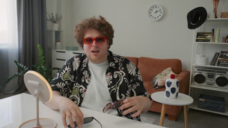 male fashion blogger reviewing trendy sunglasses and speaking to camera