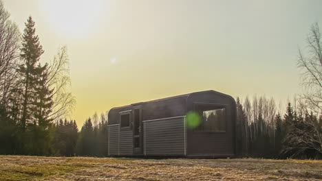 Beautiful-sunrise-during-dawn-in-rural-forest-area-with-wooden-cabin-house-after-frosty-night