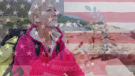 Animation-of-independence-day-text-over-senior-caucasian-woman-sitting-on-rocks