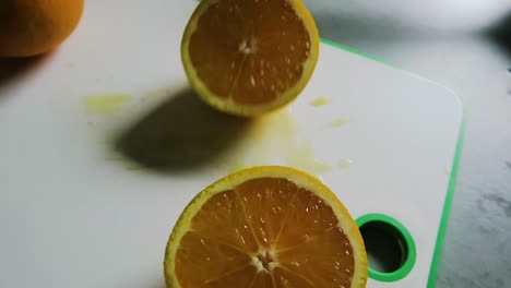 making orange juice: cutting the oranges on a chopping board close up