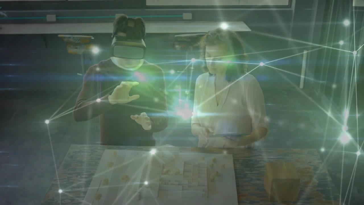 Architetto che usa un visore VR e manipola un blocco mentre il manager guida un overlay di rete