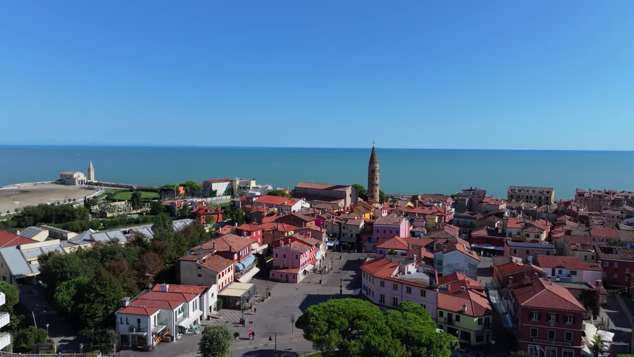rising aerial in Caorle, Italy, view of the Campanile del Duomo and the Adriatic Sea