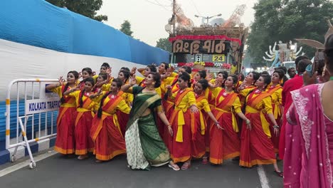 dance group of girls rehearsing their performance before durga puja procession at red road in kolkata, india.