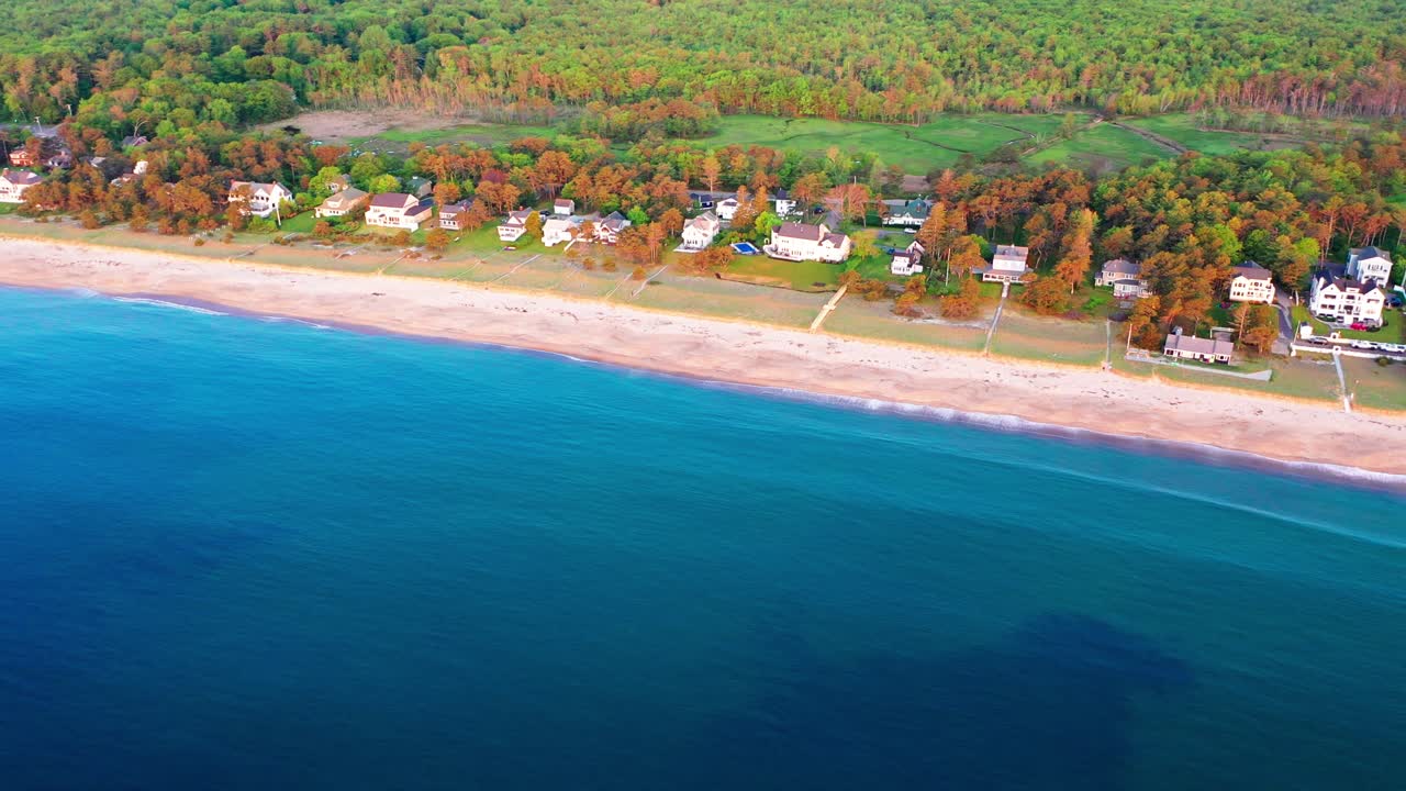 Drone captures a stunning aerial of empty beaches in Saco, Maine. Off-season coastline with no tourists, vacation houses, and blue Atlantic Ocean waves rolling over peaceful sand and scenic shoreline.