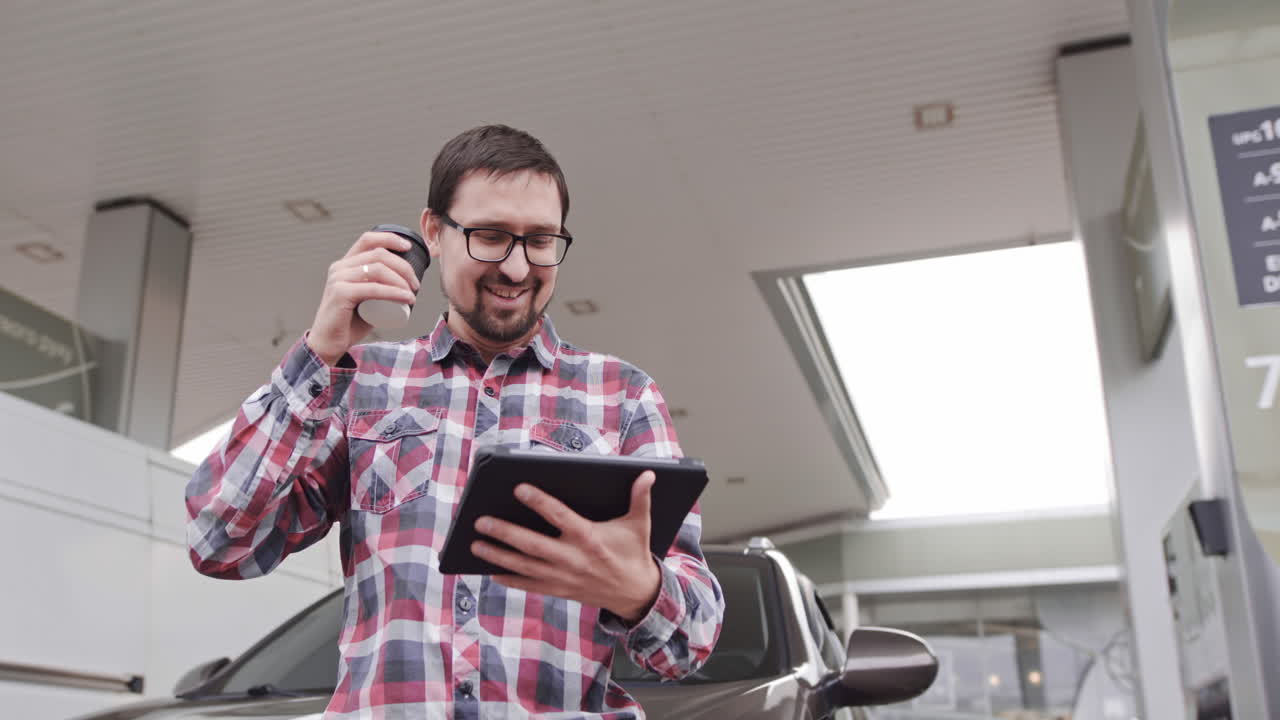 Man Using Tablet at Gas Station
