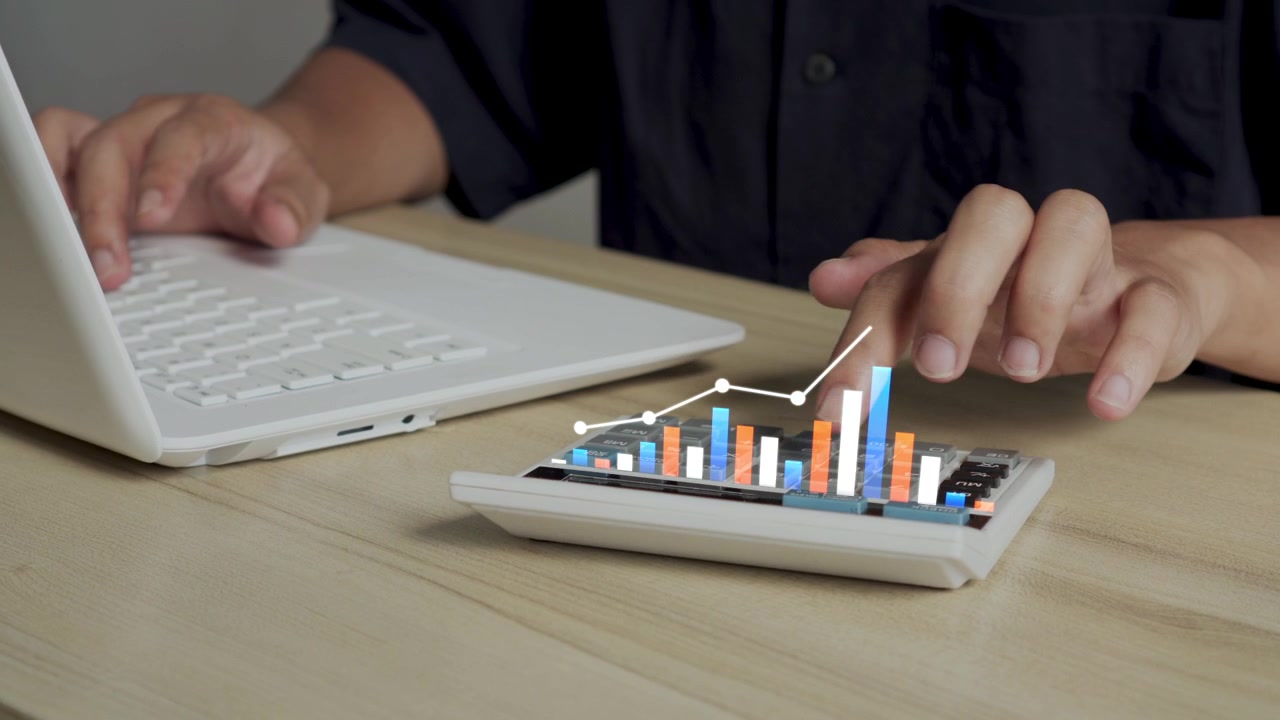 Primo piano della mano di un uomo che lavora al laptop e usa la calcolatrice mentre un grafico 3D di crescita finanziaria si anima.