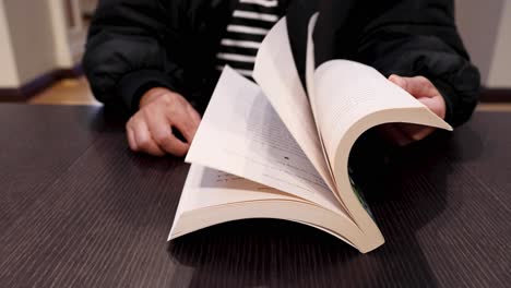 person flipping through a book's pages