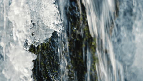 small waterfall with drop in the frozen river, static close up, slow motion