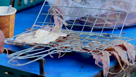 squid being grilled on a street vendor's setup