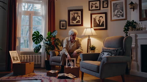 elderly woman looking through old family photos at home