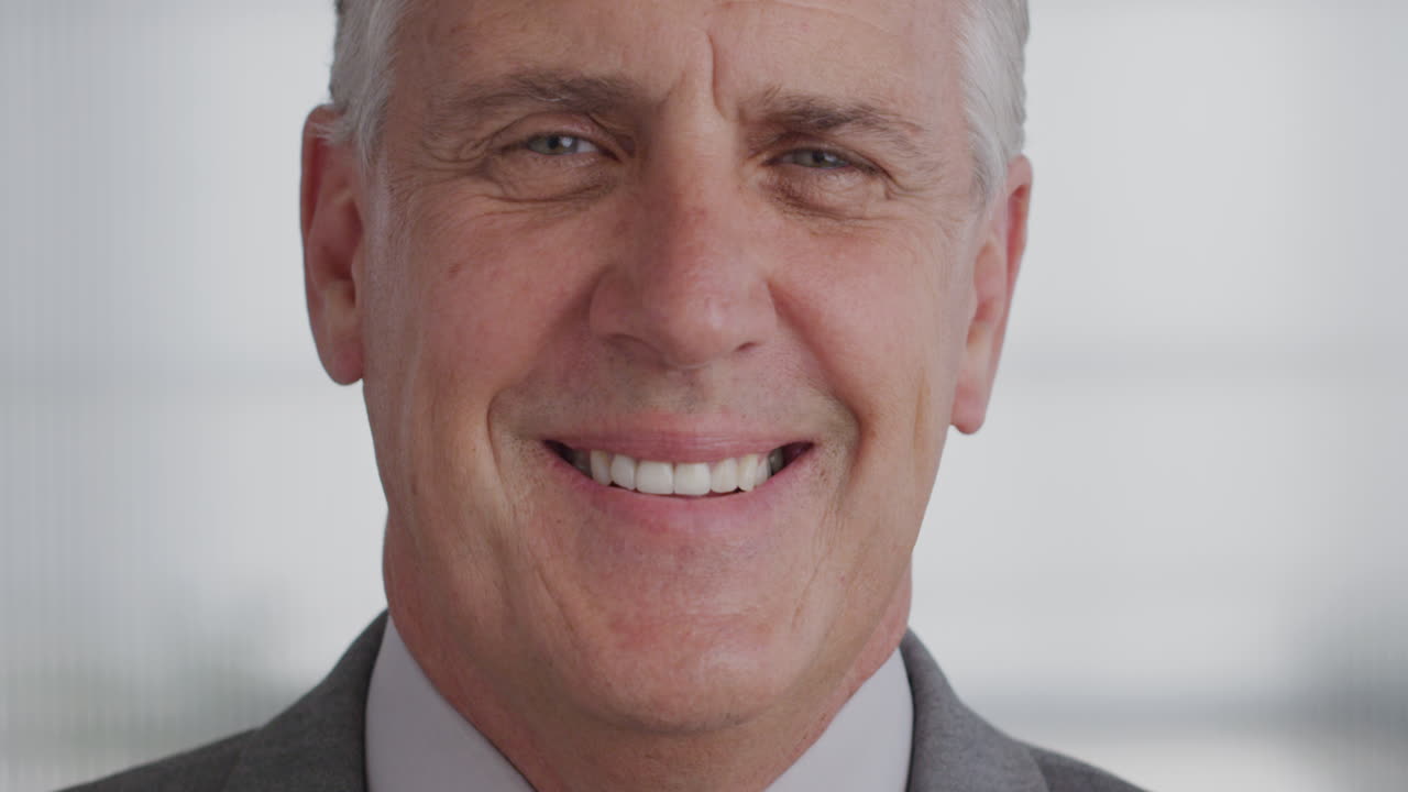 retrato de cerca de un hombre de negocios maduro sonriendo en la oficina