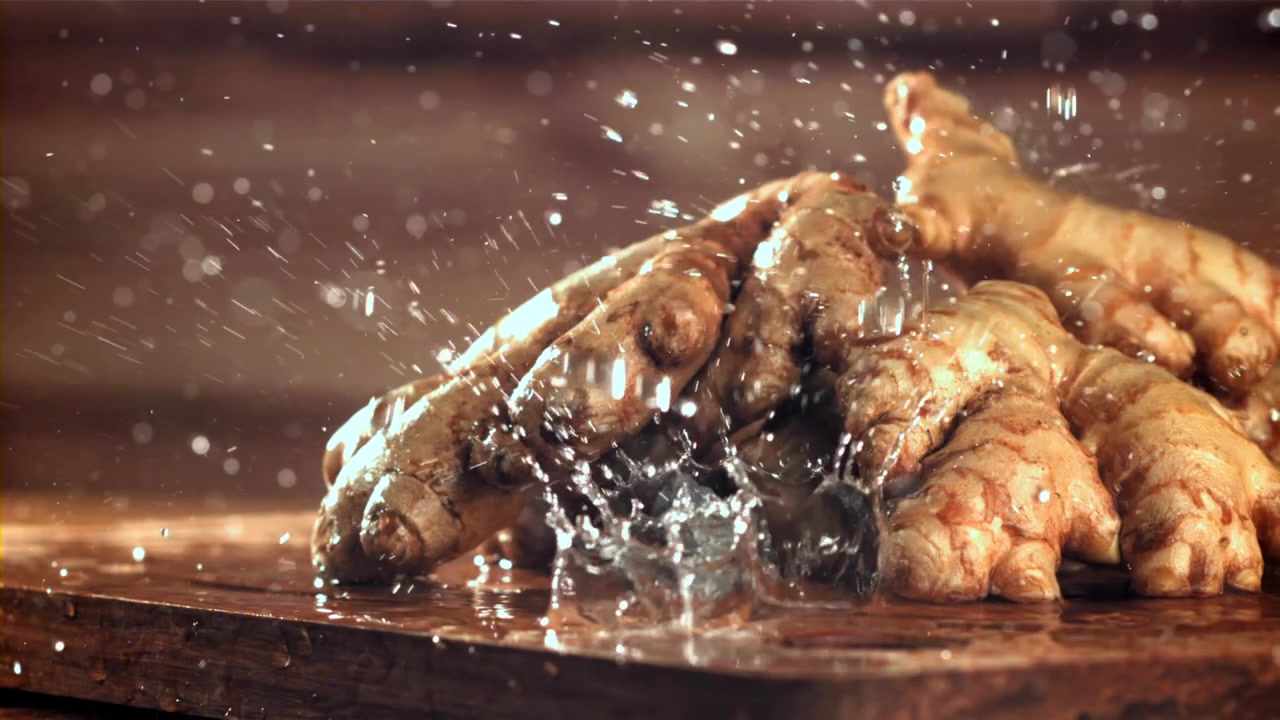Fresh Ginger Roots Being Washed with Water in Slow Motion