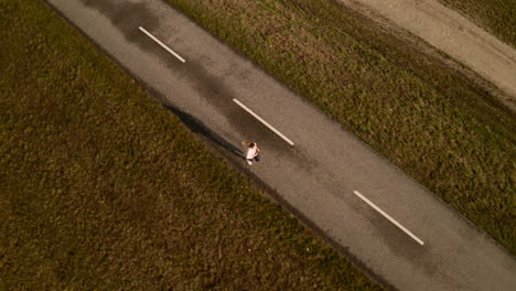 aerial view of cycling path and a slim young woman running on it