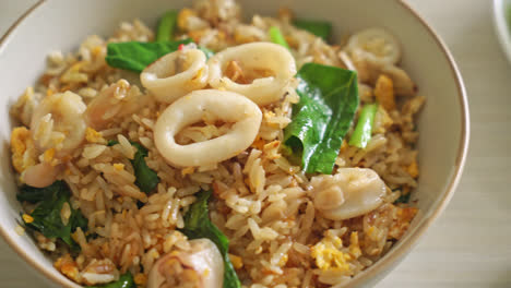 fried rice with squid or octopus in bowl - stir-fried rice with squid, egg and kale