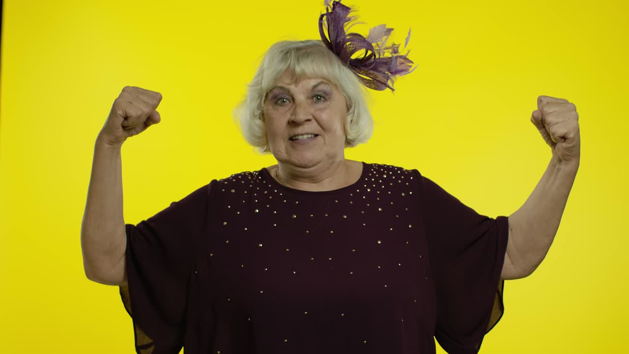 Senior woman showing biceps, looking confident, feeling power strength to fight for female rights