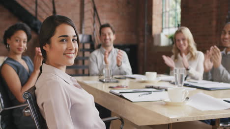 Retrato-De-Una-Joven-Mujer-De-Negocios-Segura-De-Sí-Misma-En-La-Mesa-De-La-Sala-De-Juntas-En-Cámara-Lenta-Dándose-La-Vuelta-Y-Sonriendo