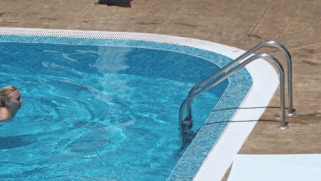 woman swimming on a blue water pool