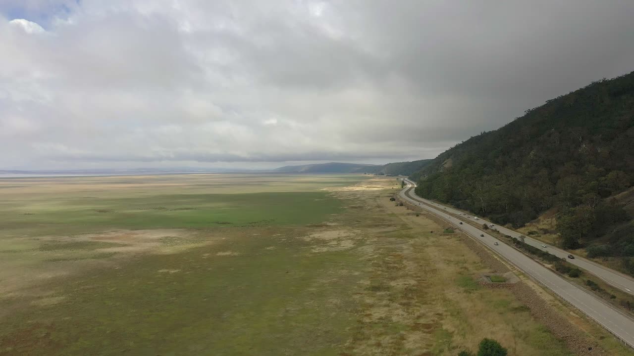volando hacia adelante a lo largo de una carretera concurrida a la derecha de la pantalla en el país nsw, australia