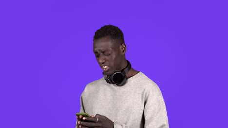 portrait of handsome young man shocked surprise, mad by what he sees on his cell phone screen, close his his face with emotions