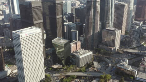 Autobahn-Neben-Der-Innenstadt-Von-Los-Angeles-Langsame-Neigung-Nach-Oben-Enthüllt-Die-Wolkenkratzerskyline-In-Schönem-Sonnenlicht,-Luftwagen-Nach-Vorne