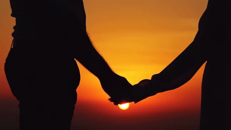 couple holding hands at sunset
