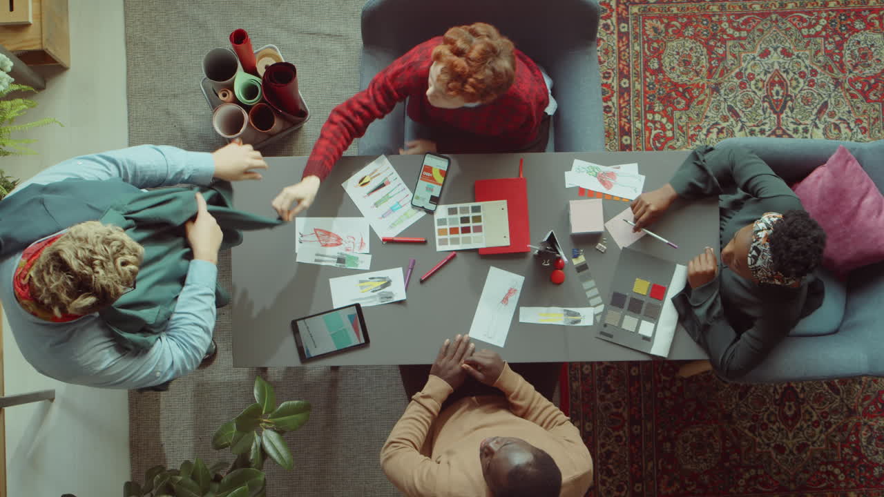 Team of Fashion Designer Discussing Clothes at Meeting
