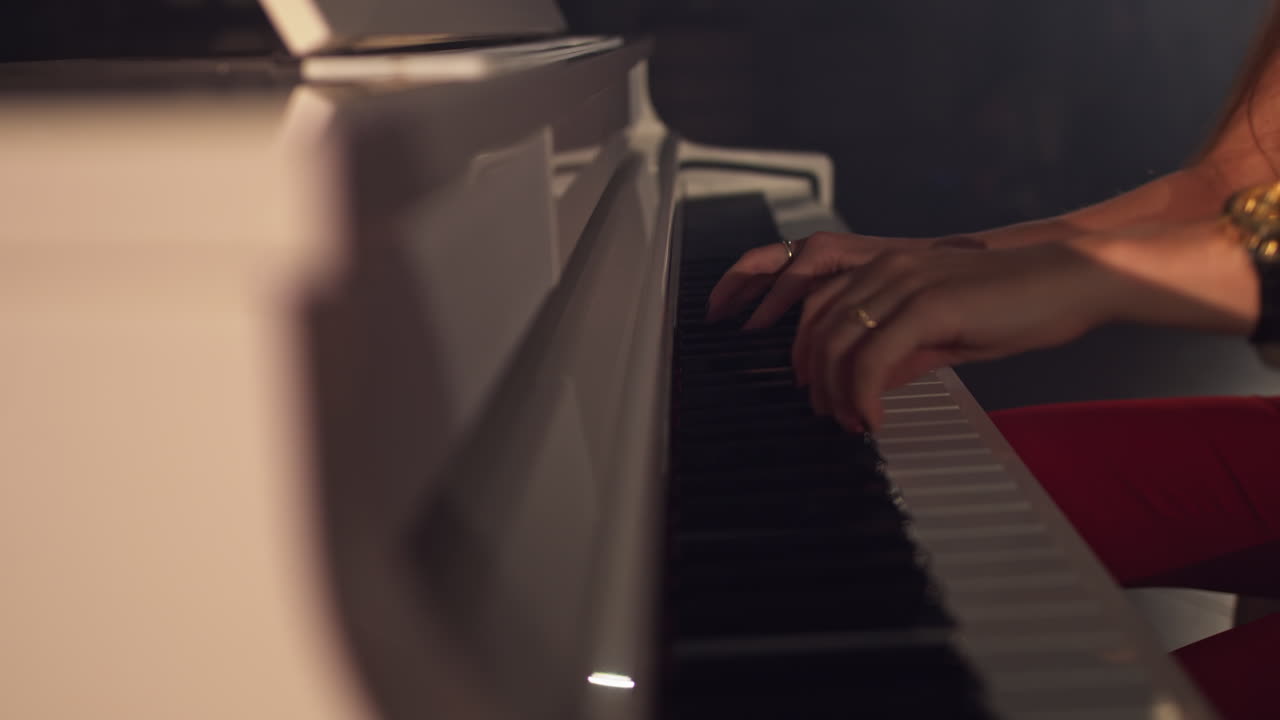 Woman pianist plays gentle classical music on a beautiful grand piano with closeup in slow motion