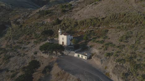 a drone zooms by the bell tower of the historic chapel in graça