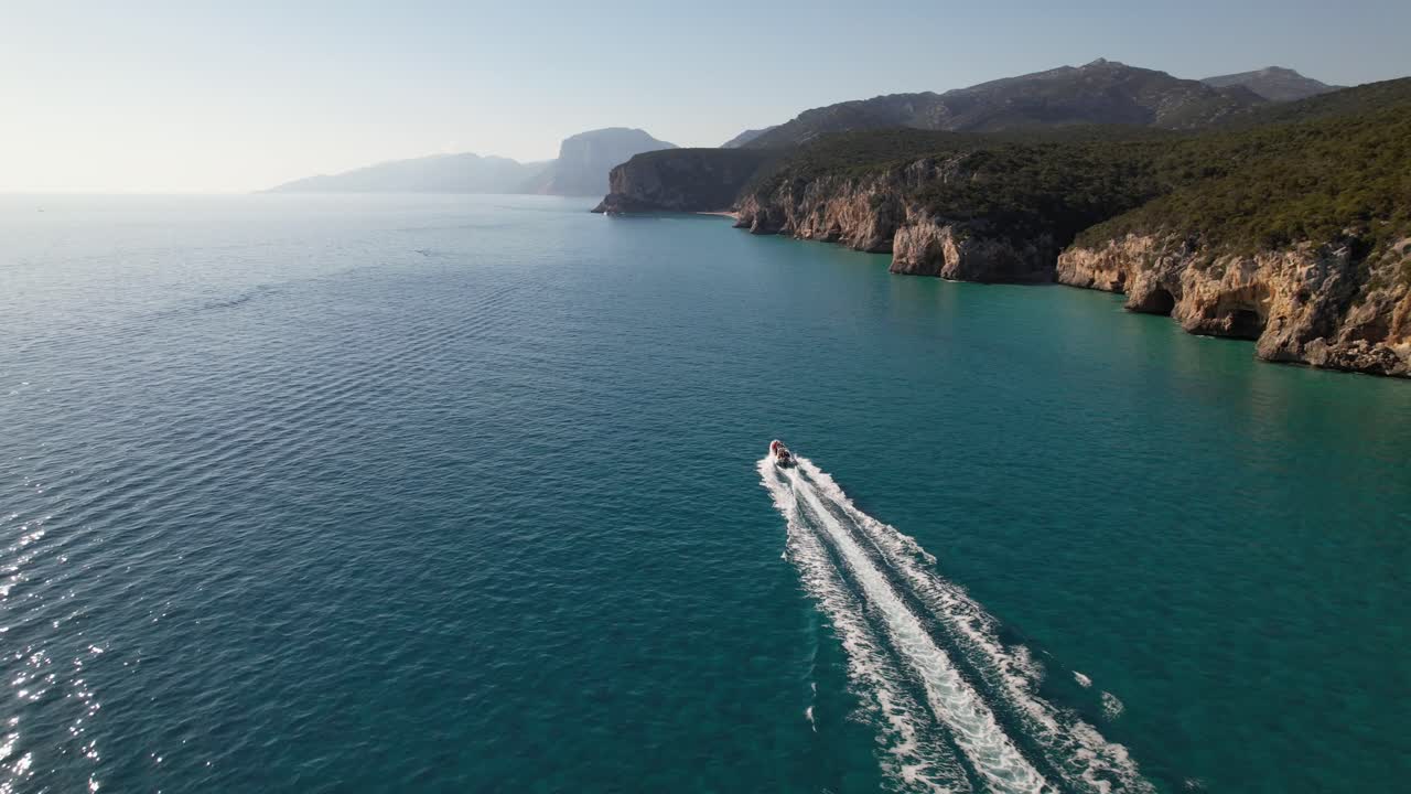 Barca che naviga lungo la costa a tutta velocità
